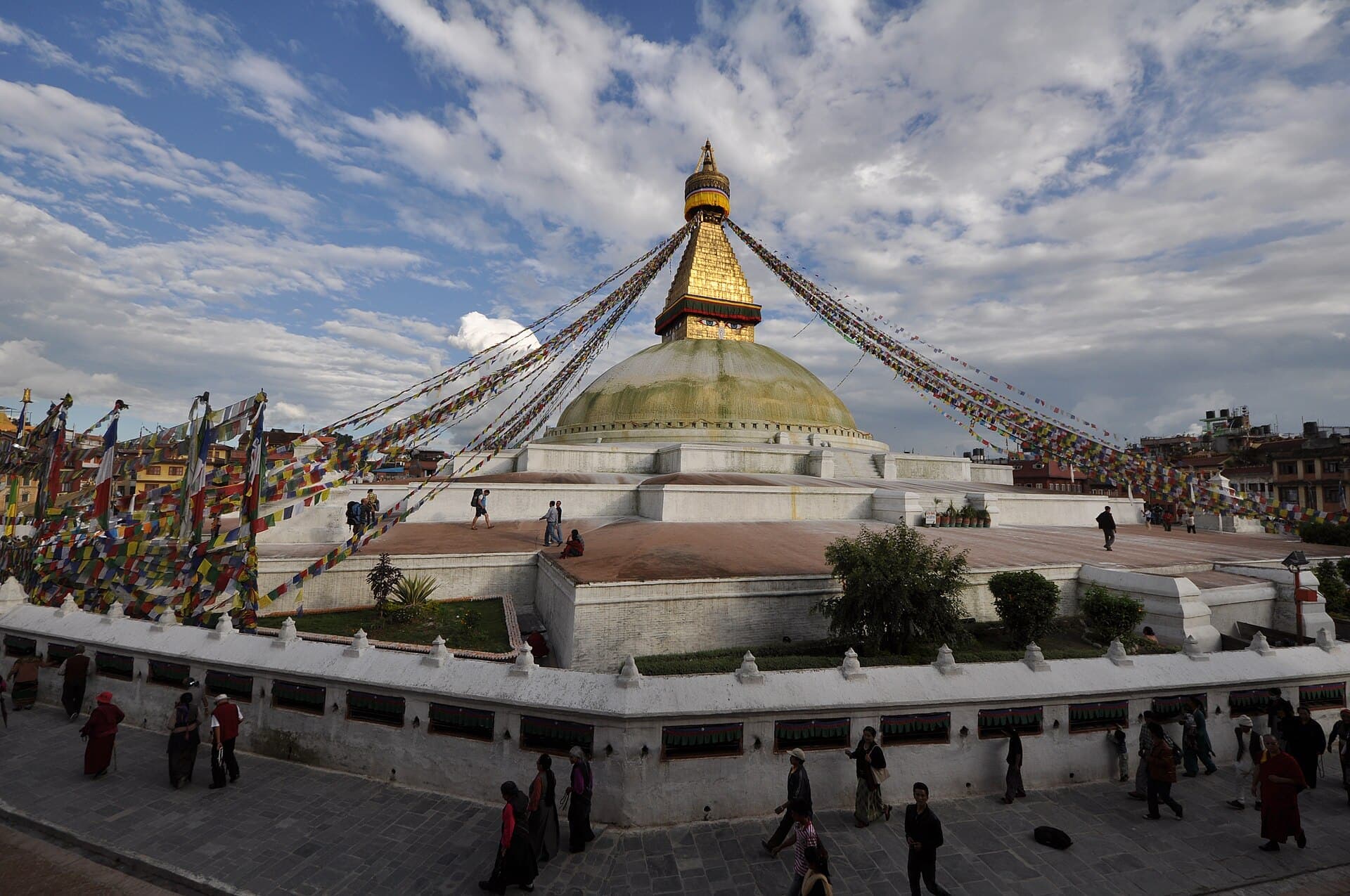 Boudhanath Stupa in Kathmandu with prayer flags and visitors walking around it